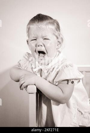 1950S INFELICE PIANGENDO BAMBINO RAGAZZA IN PIEDI IN CULLA GUARDANDO LA MACCHINA FOTOGRAFICA - J533 RGE001 HARS PAURA COMUNICAZIONE TANTRUM PREOCCUPAZIONE RUMORE STANCO ANNOYED FEMMINE MOODY LACRIME HOME VITA COPIA SPAZIO METÀ LUNGHEZZA GRIDO ESPRESSIONI TURBATO CULLA B&W INTERESSATO TRISTEZZA OCCHIO CONTATTO PIANTO ANGOSCIATO IRATE FORTE BAWLING UMORE SOBBING CONCETTUALE GLUM DISPIACERE OSTILITÀ FASTIDIOSO COMPORTAMENTO EMOZIONE CRESCITA EMOTIVA IRRITATO GIOVANI MISERABILI SQUALLING BABY GIRL BIANCO E NERO ETNICITÀ CAUCASICA DISPIACIUTA VECCHIO STILE Foto Stock