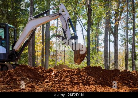 In cantiere vicino alla benna forestale di un escavatore scava terra Foto Stock