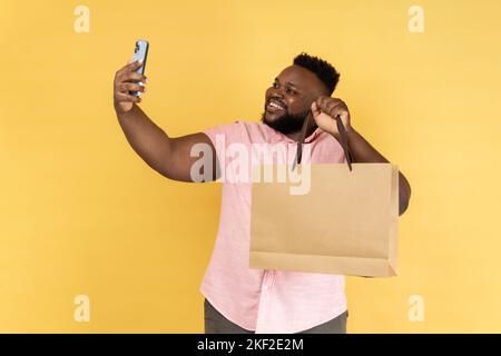 È per me. Guy soddisfatto got borsa regalo. Uomo felice ricevuto