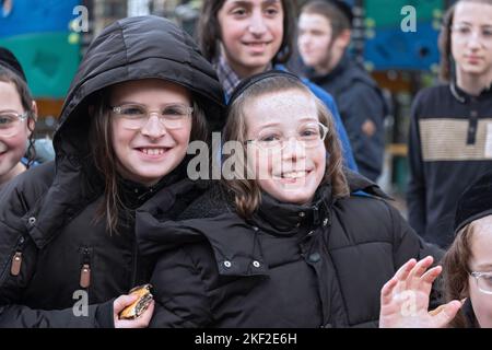 Sorridendo felici i bambini ebrei hassidici si divertono con un fotografo nel Sobel Playground di Brooklyn, New York. Foto Stock