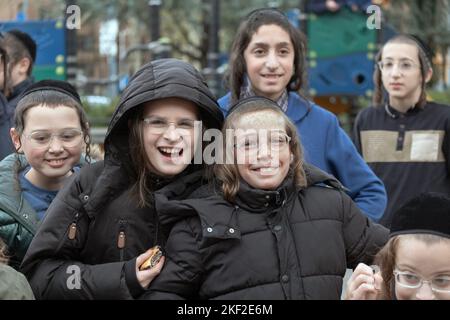 Sorridenti felici bambini ebrei hassidici divertirsi con un fotografo fuori dal Sobel Playground a Brooklyn, New York. Foto Stock