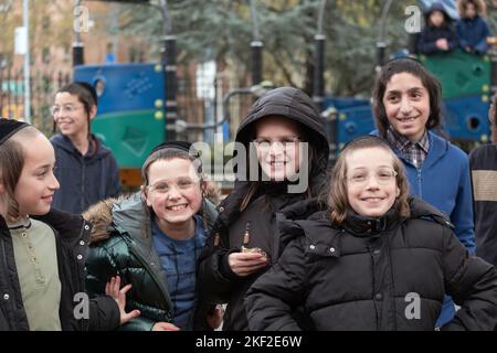 Sorridendo felici i bambini ebrei hassidici si divertono con un fotografo nel Sobel Playground di Brooklyn, New York. Foto Stock