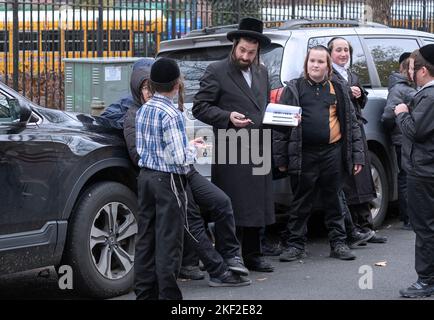 Un maestro rabbino discute gli studi ebraici con i suoi studenti durante la pausa. Fuori da un yeshiva a Brooklyn, New York City. Foto Stock