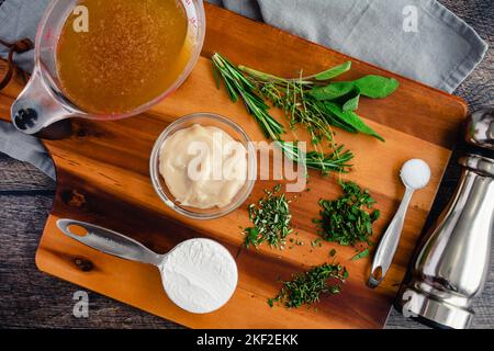 Preparazione degli ingredienti per il sugo classico: Grasso di pancetta, erbe tritate, farina e altri ingredienti per il sugo su un tagliere di legno Foto Stock