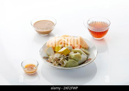 Ketoprak o Kupat Tahu, torta di riso compresso o Lontong servito con tofu, germoglio di fagioli bolliti, Karupuk e salsa di arachidi. Popolare indonesiano Street Foo Foto Stock