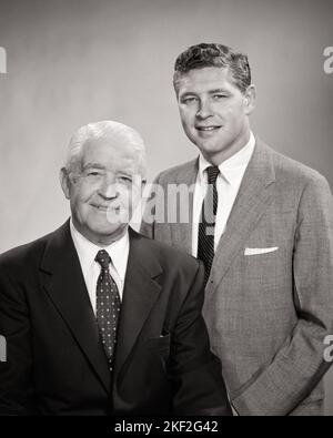 1950S RITRATTO DI UOMO PIÙ ANZIANO E PIÙ GIOVANE FIANCO A FIANCO ENTRAMBI INDOSSANDO TUTE AZIENDALI PADRE E FIGLIO PARTNER COMMERCIALI IN CERCA ALLA MACCHINA FOTOGRAFICA - S1154 HAR001 HARS SENIORS VECCHIO TEMPO FUTURO NOSTALGIA VECCHIO MODO 1 GIOVANE STILE EQUILIBRIO DI LAVORO DI SQUADRA GENERAZIONI SI ADATTA FIGLI ASTRATTO COMPIACIUTA FAMIGLIE GIOIA STILE DI VITA CELEBRAZIONE ANZIANO STUDIO SHOT HOME VITA COPIA SPAZIO MEZZA LUNGHEZZA PERSONE CURA MASCHI FIDUCIA SENIOR UOMO PADRE ADULTO SENIOR B & W OCCHIO CONTATTO SUCCESSO TUTA E CRAVATTA MENTORE FELICITÀ VECCHIAIA OLDSTERS CHEERFUL OLDSTER SIA FORZA E I DADS DIRIGANO IL PROGRESSO POTENTE ORGOGLIO DELLA GIOVANE E VECCHIA AUTORITÀ Foto Stock