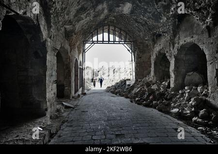 Il vecchio souk di Aleppo dopo la guerra, due persone a piedi Foto Stock