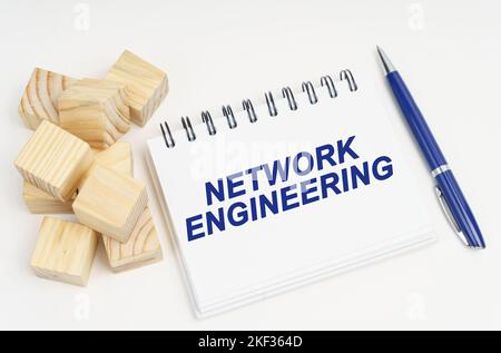 Concetto di Internet e sicurezza. Sul tavolo sono presenti cubi, una penna e un quaderno con l'iscrizione Network Engineering Foto Stock