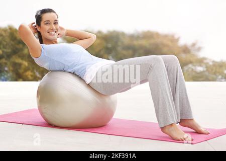 Eccitato circa il suo workout. Ritratto completo di una giovane donna che fa yoga all'aperto. Foto Stock