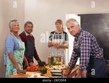 La cucina è un luogo di ritrovo per gli amici, un gruppo di persone che cucinano in cucina. Foto Stock