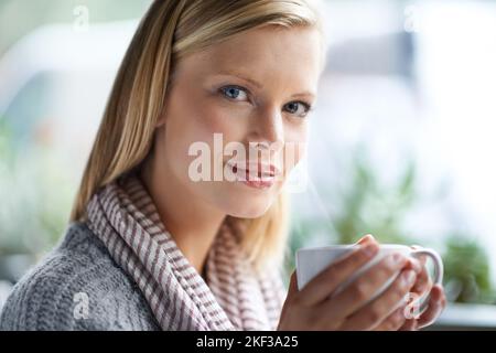 Abbiamo tutti bisogno di un posto per essere soli. Una giovane donna seduta in una caffetteria. Foto Stock