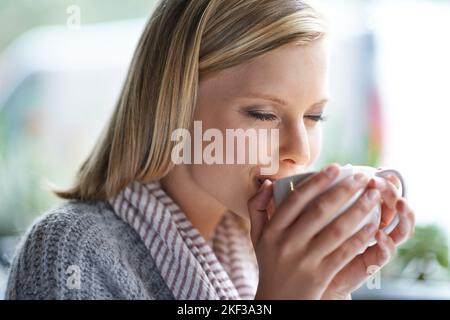 Abbiamo tutti bisogno di un posto per essere soli. Una giovane donna seduta in una caffetteria. Foto Stock