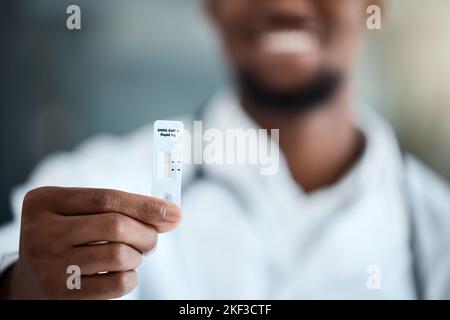 Covid, mano e antigene test rapido con un uomo nero mostrando il suo risultato negativo dopo un esame medico. Salute, benessere e assicurazione con un maschio Foto Stock