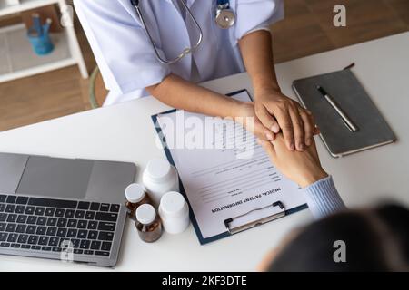 Dottore che dà speranza. Primo piano immagine di una giovane medico femminile che si appoggia in avanti a una donna anziana sorridente che tiene la mano nelle palme. Donna custode Foto Stock