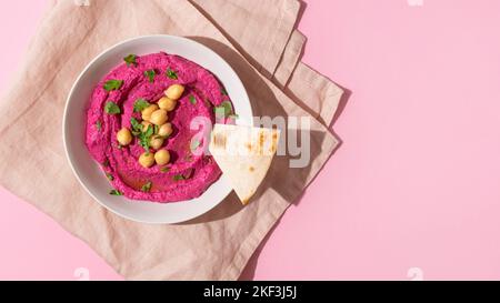 Hummus di barbabietola su sfondo rosa, vista dall'alto Foto Stock