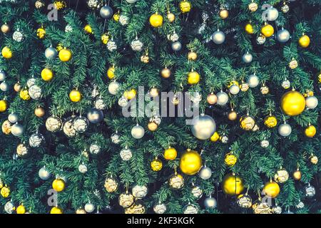 Verde albero di Natale decorazione. Palline multicolore d'oro e d'argento appese sull'albero di Natale. Foto Stock