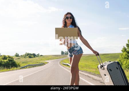 Il tuo testo qui. Concetto di viaggio e di attacco-escursione. Ritratto di felice giovane donna in piedi con vuoto. Una donna in viaggio in attesa di passi Foto Stock