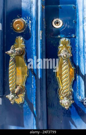 Porta in ferro bussatori su una porta di legno blu Foto Stock