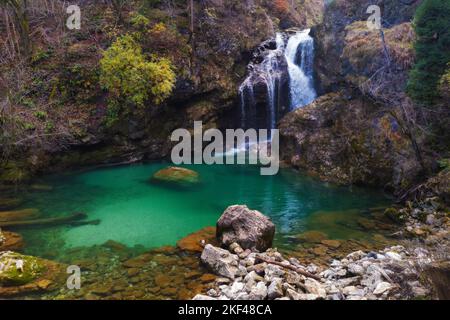 Bella cascata in autunno a Vintgar gola vicino a Bled, Slovenia. Viaggi, turismo, ambiente, stagioni e cambiamenti climatici Foto Stock