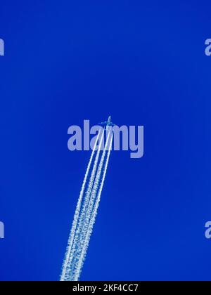 Ein Flugzeug mit Kondensstreifen am blauen Himmel. Flugreise in den Urlaub, Fernweh, Urlaub, Reisen, Foto Stock