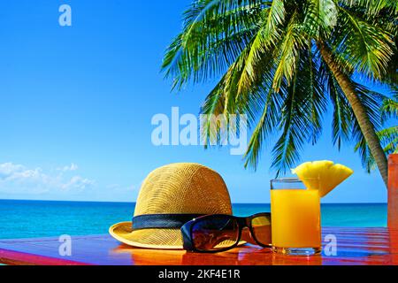 Sonnenhut mit Sonnenbrille und Fruchtsaft unter Palmen am Strand in Thailandia, Ko Samui, Koh Samui, Kho Samui, Foto Stock