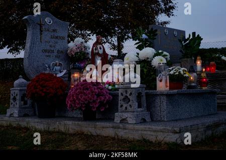 le tombe sono decorate con fiori freschi candele lanterne al cimitero rurale locale per tutti i santi giorno contea di zala ungheria Foto Stock