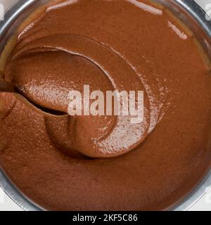 crema al caramello al cioccolato, sbattendo con un cucchiaio, composto di torta di olio closeup, preso direttamente dall'alto isolato su sfondo bianco, cibo Foto Stock