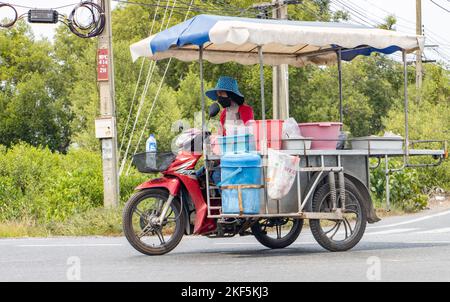 BANGKOK, THAILANDIA, 01 2022 GIUGNO, Un venditore di cibo guida un sidecar sulla strada Foto Stock