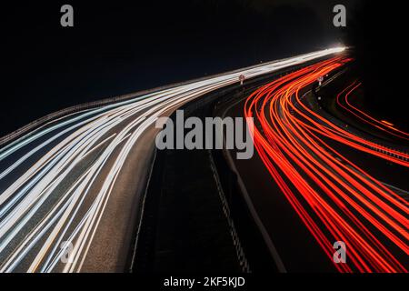 Luci offuscate del camion. Immagine astratta dei semafori notturni sulla strada. Auto sentieri luce di notte in curva asfaltata strada. Esposizione lunga Foto Stock