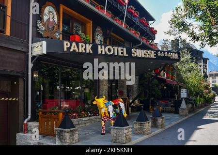 Esterno dell'hotel decorato con dipinti murali e una scultura in resina 'Picasso cow', Chamonix, alta Savoia, Francia Foto Stock