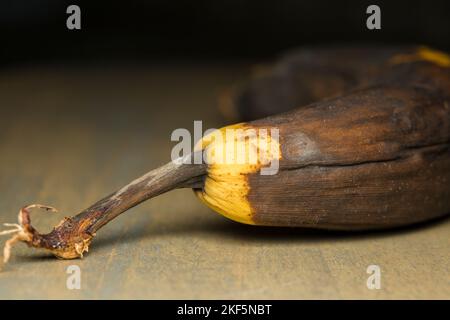 Banana nera su un asse di legno. Foto Stock