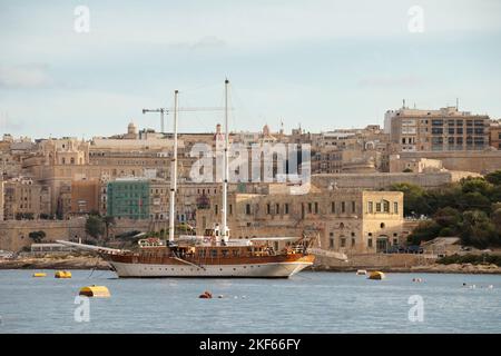 Floriana, Malta - 11 novembre 2022: Vista panoramica della Valletta e della Floriana da Sliema, con barca a vela, in una giornata di sole nuvolose Foto Stock