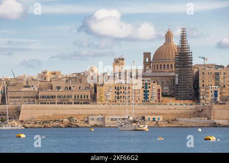 Valletta, Malta - 11 novembre 2022: Vista panoramica della capitale da Sliema, con barca a vela e campanile in restauro, su un clone soleggiato Foto Stock