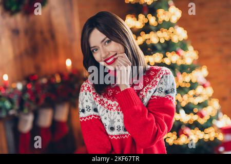 Ritratto foto di giovane bella ragazza morso il suo dito toothy beaming sorriso chiedere babbo natale nuovo anno regalo auto sportiva vicino all'albero di Natale al coperto Foto Stock