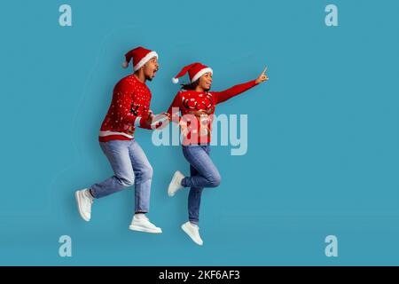 Coppia di xmas nero amorevole che punta allo spazio della copia Foto Stock