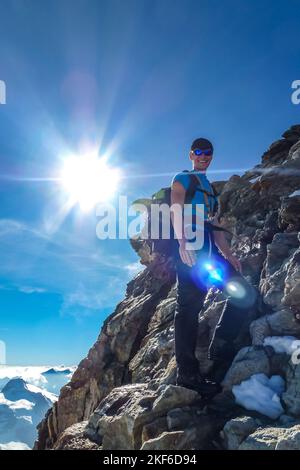 Descrizione: Alpinista arrampicata su ripido terreno roccioso su Jungfrau. Jungfrau-Höhenweg, Alpi Bernesi, Svizzera, Europa. Foto Stock