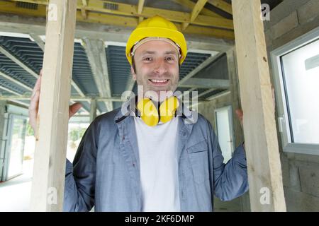 lavoratore che dimostra l'importanza di indossare cuffie a cancellazione di rumore Foto Stock