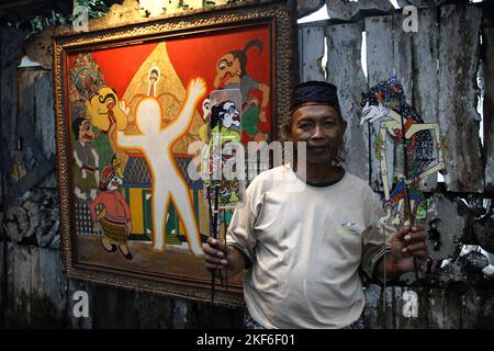 16 novembre 2022, Yogyakarta, Regione Speciale di Yogyakarta, Indonesia: Artista 'Wayang uwuh', ISKANDAR HARDJODIMULJO (61) posa nella sua casa a Yogyakarta, Indonesia. Il wayang uwuh, costituito da rifiuti domestici come bottiglie di acqua minerale usate, involucri alimentari di cartone e plastica, è venduto per 25.000 IDR a 2 milioni di IDR. (Credit Image: © Angga Budhiyanto/ZUMA Press Wire) Foto Stock