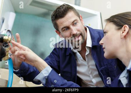 lavoratori che utilizzano un manometro positivo analogico Foto Stock