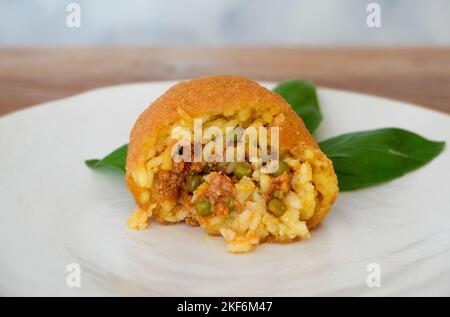 Arancino fritto, piselli con salsa di carne e basilico, cibo tradizionale siciliano, Italia Foto Stock