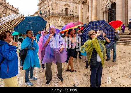 Turisti fuori dalla Cattedrale in Una giornata piovosa, Ortigia, Siracusa, Sicilia, Italia Foto Stock