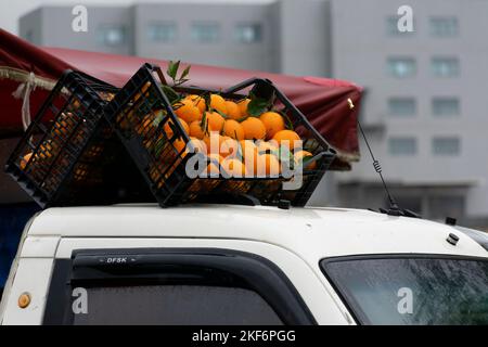 Casse arancioni sul tetto di un mini-camion. Affiancati in posizione simmetrica. Bagnare con gocce d'acqua in una giornata piovosa. Parte rossa della tenda. Foto Stock