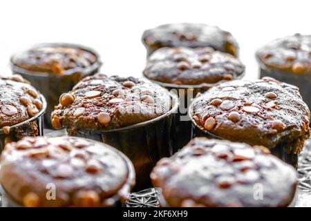 Muffin con patatine al cioccolato macrofotografia fatta in casa, luce del sole bianca che splende da un lato. Messa a fuoco selettiva con profondità di campo ridotta. Foto Stock