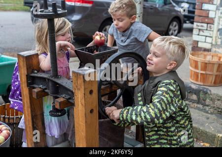 Detroit, Michigan - i bambini fanno sidro di mele con una pressa della mela ad un festival di caduta sul lato vicino orientale di Detroit. Foto Stock