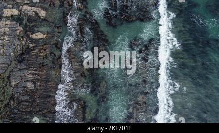 Le onde si rompono sulla costa rocciosa del Mar Celtico, vista dall'alto. Schiuma bianca sulle onde. La costa dell'Atlantico. Acqua turchese. Mari mozzafiato Foto Stock