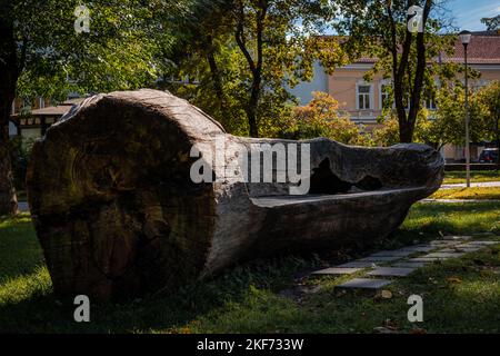 Vilnius, Lituania - 26 settembre 2022: Una panca di legno naturale fatta di un albero caduto nel Giardino Bernardino. Foto Stock