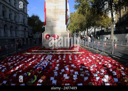 Corone posate al memoriale Cenotaph a Whitehall, Londra, Regno Unito il 16 novembre 2022, con i membri del pubblico che guardano da parte. Foto Stock