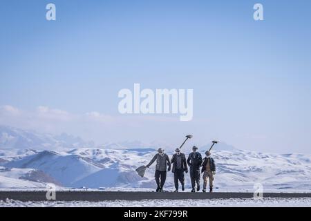 Bamyan, Afghanistan. 16th Nov 2022. Quattro operai afghani sono sulla strada per lavorare a terra sulle montagne innevate della provincia afghana di Bamyan. Credit: Oliver Weiken/dpa/Alamy Live News Foto Stock