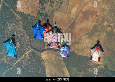 I paracadutisti volano una formazione in tute alari attraverso la campagna spagnola Foto Stock