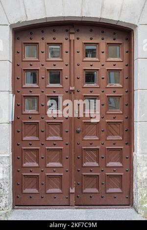 Estonia, Tallinn - 21 luglio 2022: Porta marrone elegante con 12 piccole finestre a Pikk 62, dove le camere possono essere affittate. Foto Stock